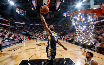 NBA季后赛赛场，球员高高跃起扣篮的瞬间