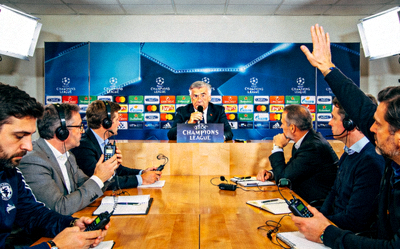 欧冠赛后新闻发布会现场，主教练正在回答记者提问